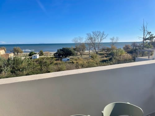 Vista della spiaggia di Marina di Bravone dal balcone a Linguizzetta, con mare, sabbia e paesaggio mediterraneo