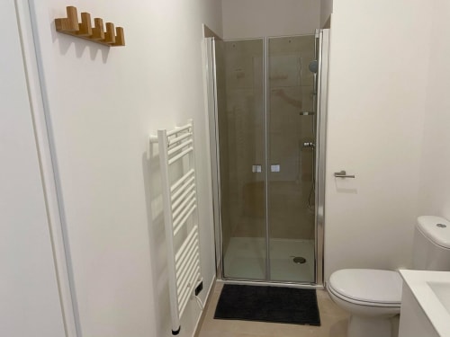 Bagno moderno della Résidence Marina di Bravone con doccia in vetro, scaldasalviette e WC