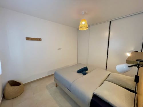 Camera da letto minimalista presso la Résidence Marina di Bravone in Corsica con letti gemelli, lampada a sospensione e arredamento moderno