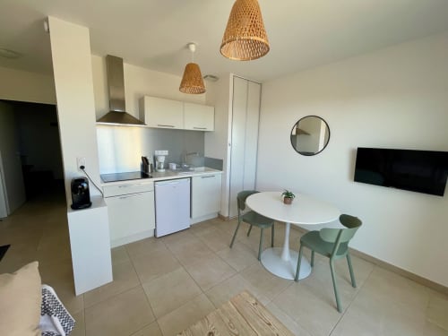 Moderno monolocale a Marina di Bravone con cucina, zona pranzo e lampade a sospensione intrecciate con vista sulla spiaggia
