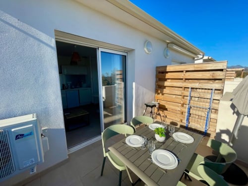 Terrazza panoramica a Marina di Bravone, Linguizzetta con tavolo da pranzo, sedie verdi, pannello in legno e vista sul mare