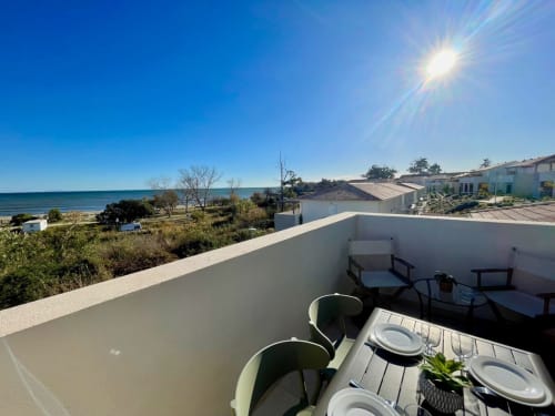 Terrazza fronte mare della Résidence Marina di Bravone in Corsica con vista sul mare, arredamento da pranzo e paesaggio costiero