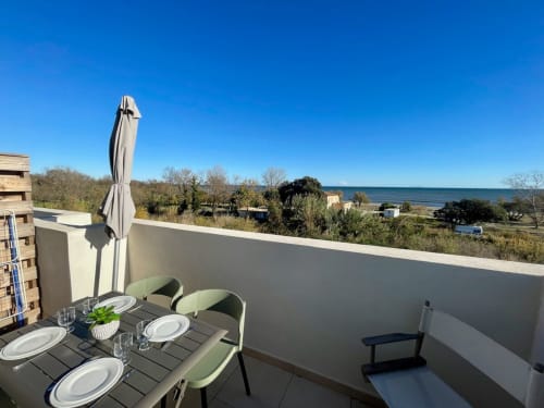 Terrazza dell'appartamento Marina di Bravone con vista mare, tavolo da pranzo e ombrellone sulla spiaggia di Linguizzetta