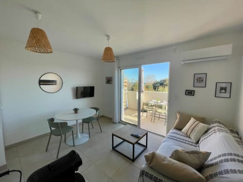 Moderno appartamento a Résidence Marina di Bravone con living, divano, tavolo da pranzo e balcone con vista mare a Linguizzetta