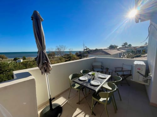 Terrazza sul mare a Marina di Bravone con tavolo da pranzo, ombrellone e vista oceano a Linguizzetta, Corsica