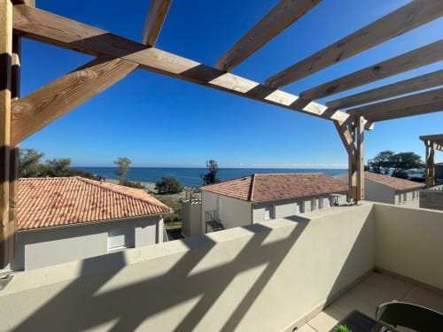 Terrazza studio con vista mare presso Résidence Marina di Bravone, pergolato in legno, vista sul Mediterraneo e architettura caratteristica