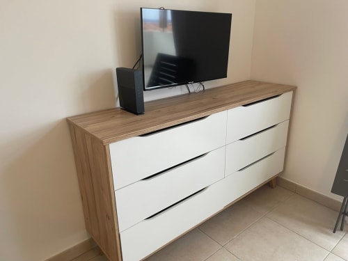 Camera da letto moderna presso Résidence Marina di Bravone con cassettone in legno, TV e pareti beige a Linguizzetta, Corsica