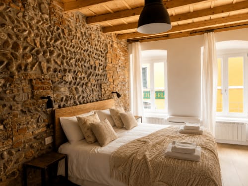 Gemütliches Schlafzimmer im Zentrum von Bergamo mit Natursteinwänden, Holzbalken und modernen Annehmlichkeiten