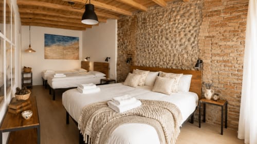 Ampia camera da letto a Bergamo con mattoni a vista, travi in legno, due letti e comfort moderni