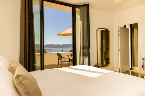 Camera lusso all'Hôtel Villa Martini di Ajaccio con balcone vista mare, ombrellone e arredi moderni