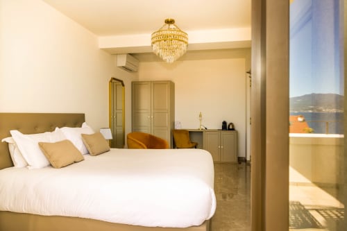 Camera elegante dell'hotel Villa Martini ad Ajaccio con vista mare, arredi moderni e lampadario