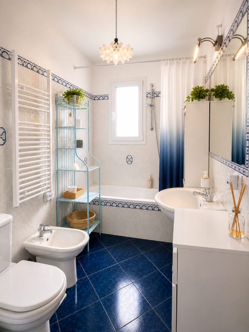 Salle de bain moderne de l'appartement Dragonniere chic, Riviera Home, Roquebrune-Cap Martin avec carrelage bleu et sanitaires blancs