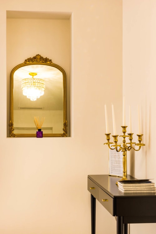 Elegante ingresso dell'Hôtel Villa Martini Ajaccio con specchio dorato, lampadario e candelabro su tavolo console