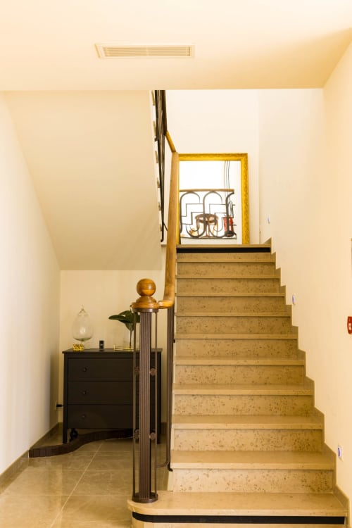 Ingresso a scale dell'Hôtel Villa Martini ad Ajaccio con gradini in pietra beige, cassettone nero e finestra con cornice dorata