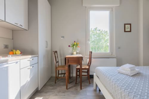 Camera moderna con angolo cottura, tavolo da pranzo e letto con vista sulla città presso il Prince Garda hotel a Solarolo