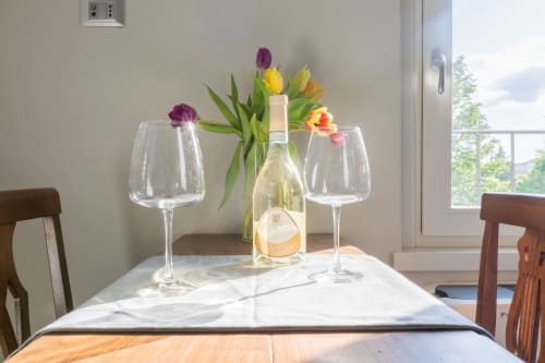 Bottiglia di vino con tulipani e bicchieri vuoti sul tavolo presso l'Hotel Prince Garda a Solarolo