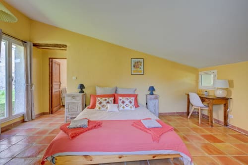 Chambre lumineuse jaune vif avec literie corail au Domaine Bellavigne Gîtes, Forcalquier