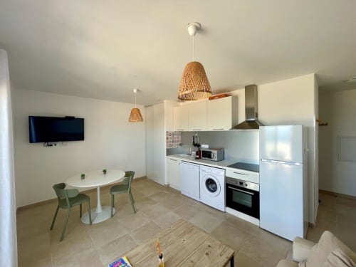 Cuisine moderne et salle à manger du T3 à la Résidence Marina di Bravone, Linguizzetta avec luminaires en suspension tressés et vue mer
