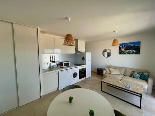 Appartement moderne à la Résidence Marina di Bravone en Corse avec cuisine ouverte, séjour et mobilier contemporain