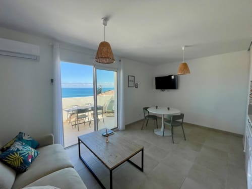 Appartement moderne à la Résidence Marina di Bravone avec vue mer, coin repas et terrasse meublée face à la plage