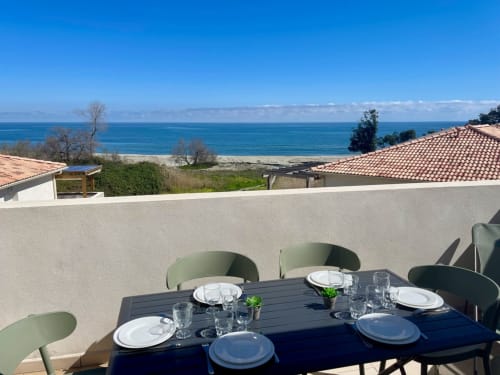 Terrasse vue panoramique sur la mer à la Résidence Marina di Bravone, Corse avec espace repas et littoral méditerranéen