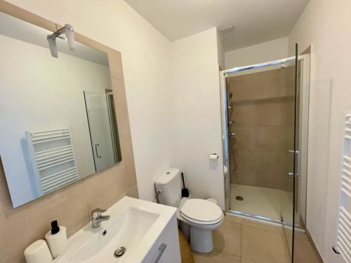 Bagno moderno nell'appartamento del resort Marina di Bravone con lavabo, water, box doccia e scaldasalviette radianti