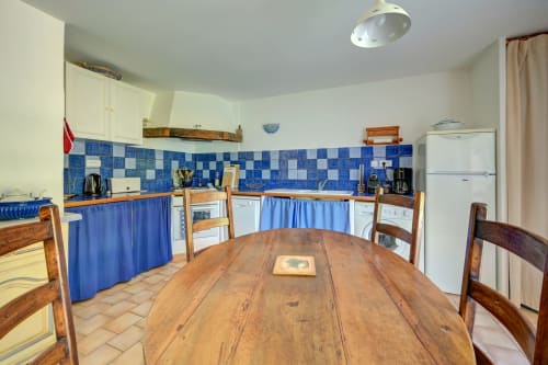 Spacieuse cuisine et salle à manger aux Gîtes Domaine Bellavigne avec dosseret de carreaux bleus et table en bois