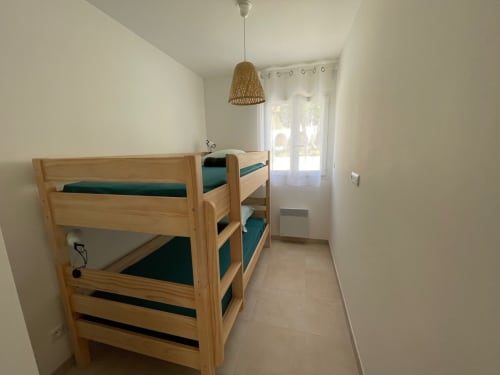 Bright twin bedroom in Marina di Bravone apartment with wooden bunk beds and teal bedding