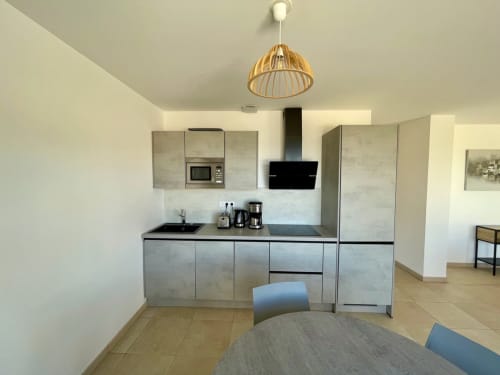 Cucina moderna in ampio appartamento T3 a Résidence Marina di Bravone, Linguizzetta con mobili in acciaio inossidabile e zona pranzo