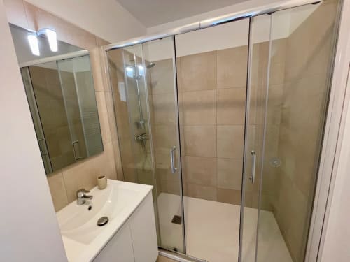 Bagno moderno con box doccia in vetro alla Résidence Marina di Bravone, Linguizzetta. Lavabo bianco, piastrelle beige, cromature