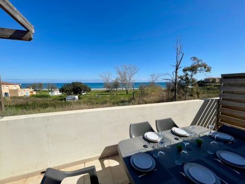 Terrazza fronte mare di Résidence Marina di Bravone con vista sul mare, zona pranzo e paesaggio corso a Linguizzetta
