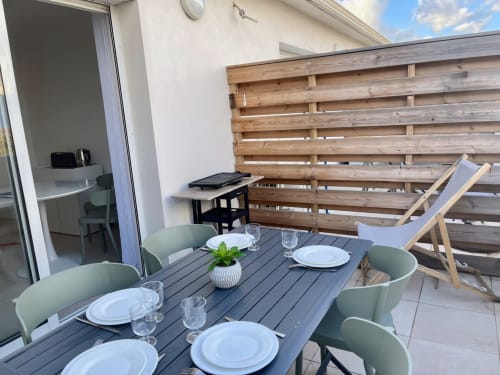 Terrasse Marina di Bravone avec table à manger, vue mer, écran de confidentialité en bois et accès plage à Linguizzetta