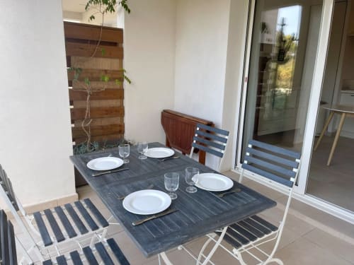 Angolo pranzo esterna presso l'appartamento Marina di Bravone con tavolo, sedie, tovagliato e schermo privacy in legno