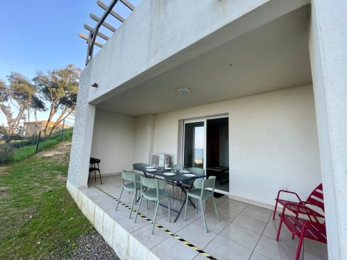 Beachfront apartment patio at Résidence Marina di Bravone, Linguizzetta with dining table and sea views