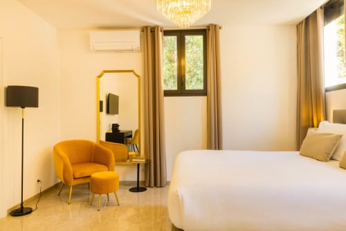 Lussuosa Camera DeLuxe con vista giardino all'Hôtel Villa Martini di Ajaccio, arredi moderni e dettagli dorati