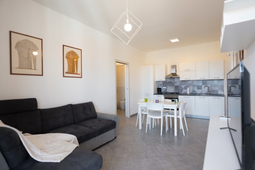 Appartamento Maestrale moderno a Finale Ligure con cucina open-plan, zona pranzo, divano nero e vista sul mare
