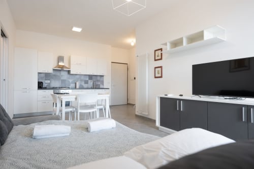 Moderno appartamento Maestrale a Finale Ligure con cucina a vista, salotto, TV a schermo piatto e camera arredata