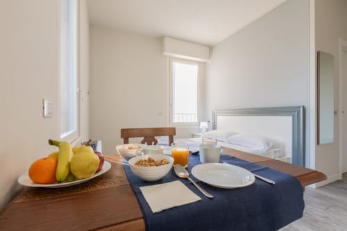 Camera dell'hotel Prince Garda a Solarolo con colazione allestita, piatto di frutta, ciotola di cereali e letto visibile