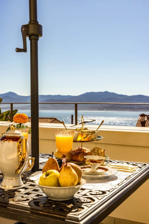 Colazione di lusso con vista sul mare sulla terrazza privata dell'Hôtel Villa Martini, Ajaccio, affacciata sul Mediterraneo con montagne