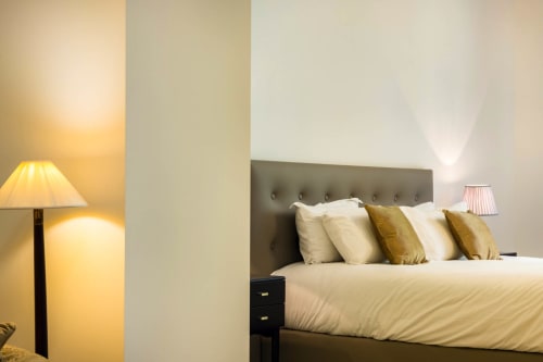 Camera Executive Suite dell'Hôtel Villa Martini ad Ajaccio con testata imbottita, cuscini dorati e lampada da comodino