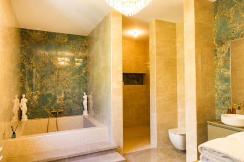 Lussuosa suite bagni all'Hôtel Villa Martini di Ajaccio con vasca in marmo, doccia a pioggia e pareti in pietra verde-oro