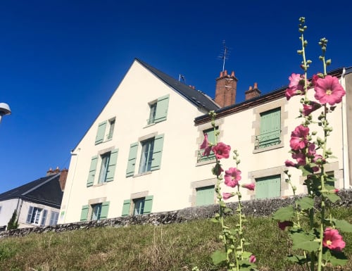 Gîte La Vue Loire Cottage mit rosa Blüten und grünen Fensterladen in Saint-Denis-de-l'Hôtel, Frankreich