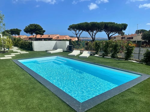 Rectangular swimming pool with blue water on manicured lawn at Like at Home Palau hotel in Sardinia
