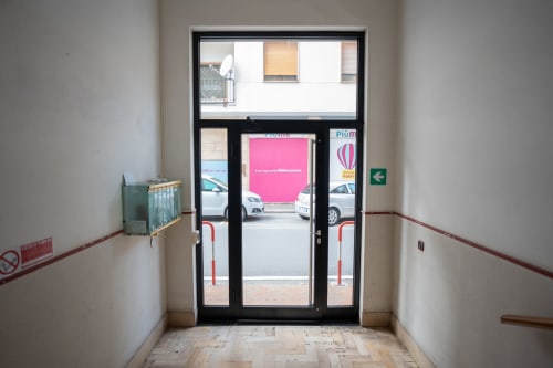 Ingresso dell'appartamento Maestrale presso Welcome Holiday, Varigotti, con porte in vetro che si aprono sull'area parcheggio