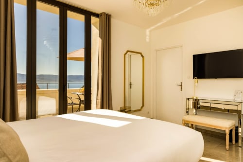 Camera di lusso all'Hôtel Villa Martini di Ajaccio con balcone vista mare, letto bianco, TV e dettagli dorati