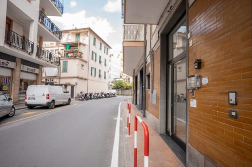 Vista della strada dell'apparthotel Welcome Holiday a Varigotti, Finale Ligure con paletti rossi e bianchi e facciata in mattoni