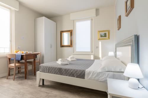 Camera da letto dell'Hotel Prince Garda a Solarolo con letto, scrivania, armadio e luminosa luce naturale