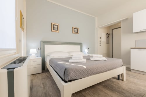 Camera moderna dell'hotel Prince Garda a Solarolo con letto matrimoniale, arredamento bianco e design minimalista