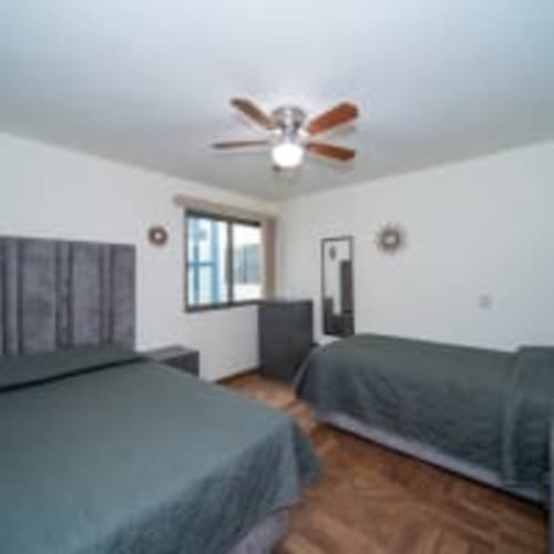 Habitación espaciosa con camas gemelas, ventilador de techo y vista a la ciudad en Apartamentos Posada Country, Guadalajara
