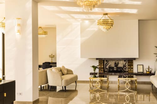 Elegant Hotel Villa Martini lobby in Ajaccio with golden chandeliers, cream seating, and polished marble floors.